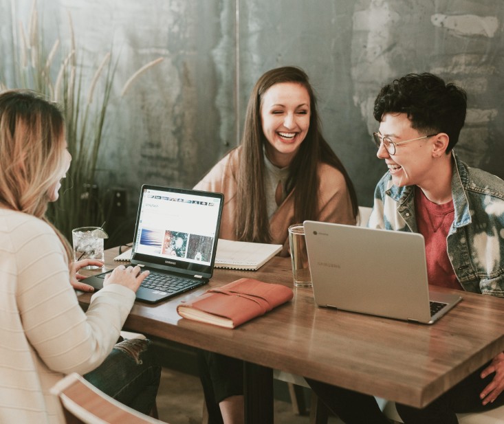 Three laughing womens in office with computers