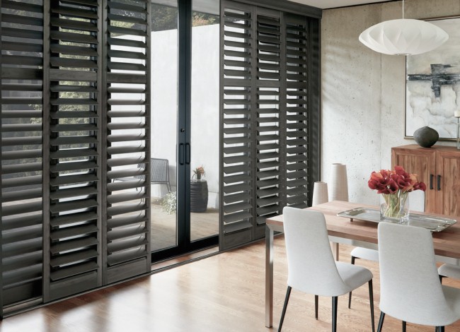 Modern living room with big windows and dark blinds